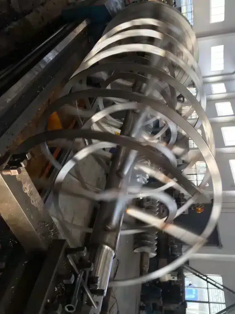 Spiraling blades of a large horizontal ribbon mixer used for industrial mixing and blending applications in a factory setting. 螺带混合机