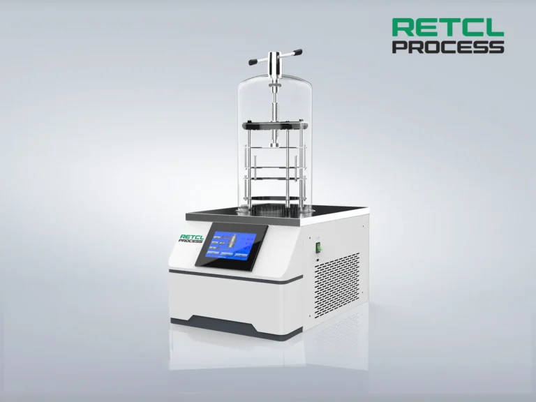 A benchtop freeze dryer by RETL Process with a digital touchscreen interface, transparent drying chamber, and shelf system, set against a gradient grey background.
