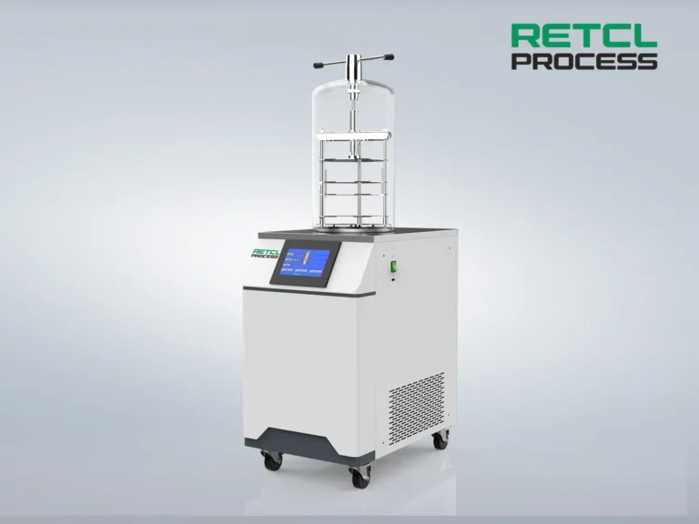 A benchtop freeze dryer with a digital control panel, clear drying chamber, and mounted on wheels, displayed against a plain background.
