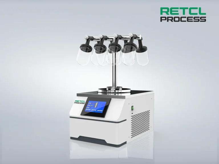 A benchtop freeze dryer by RETL Process with a digital display interface and multiple flask attachments on top, against a gray background.